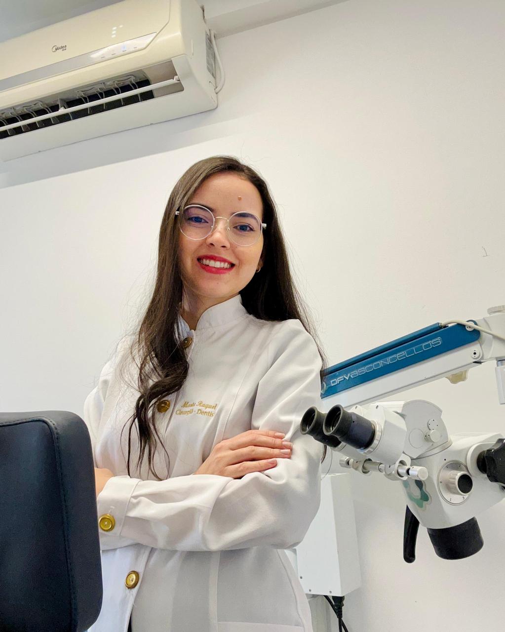 Dra. Marta Raquel ao lado do microscópio odontológico